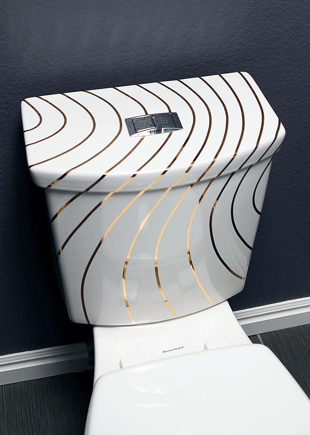 blue powder room with gold lines painted on American standard toilet