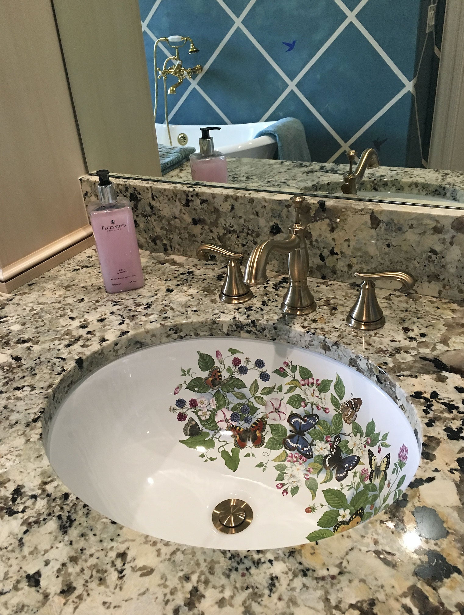 Unique bathroom with granite counter and butterflies, fruit and flowers painted bathroom sink.