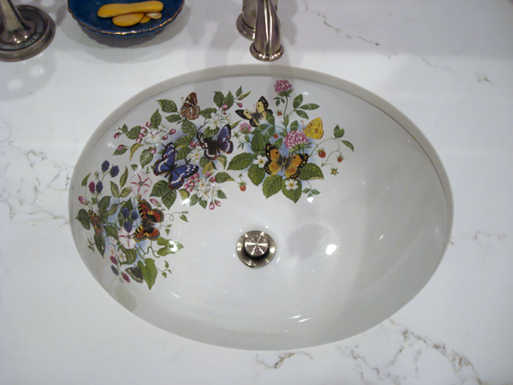Small bathroom sink painted with Butterflies, Fruit and Flowers design in marble counter