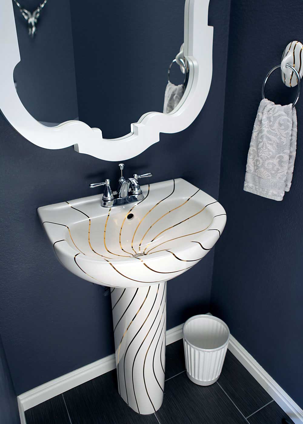 Dark blue powder room with hand painted modern gold design pedestal sink