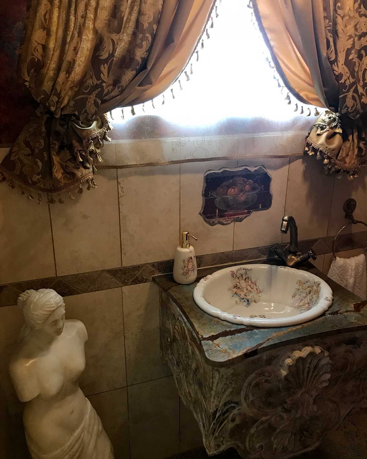 Old world style romantic bathroom Sith the cherubs design painted on the sink.