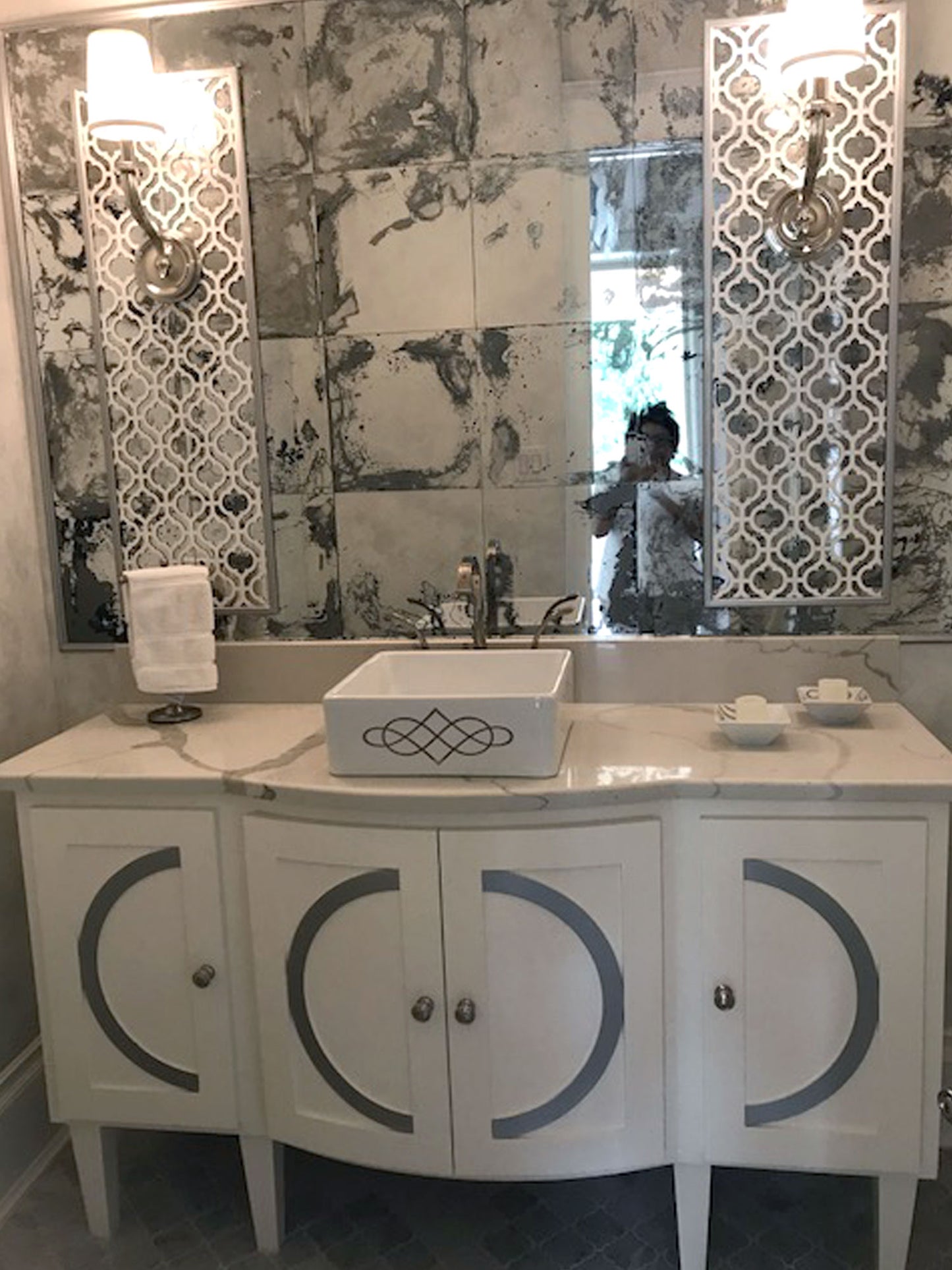Eclectic bathroom with mirrors and vessel sink painted with double swirl design
