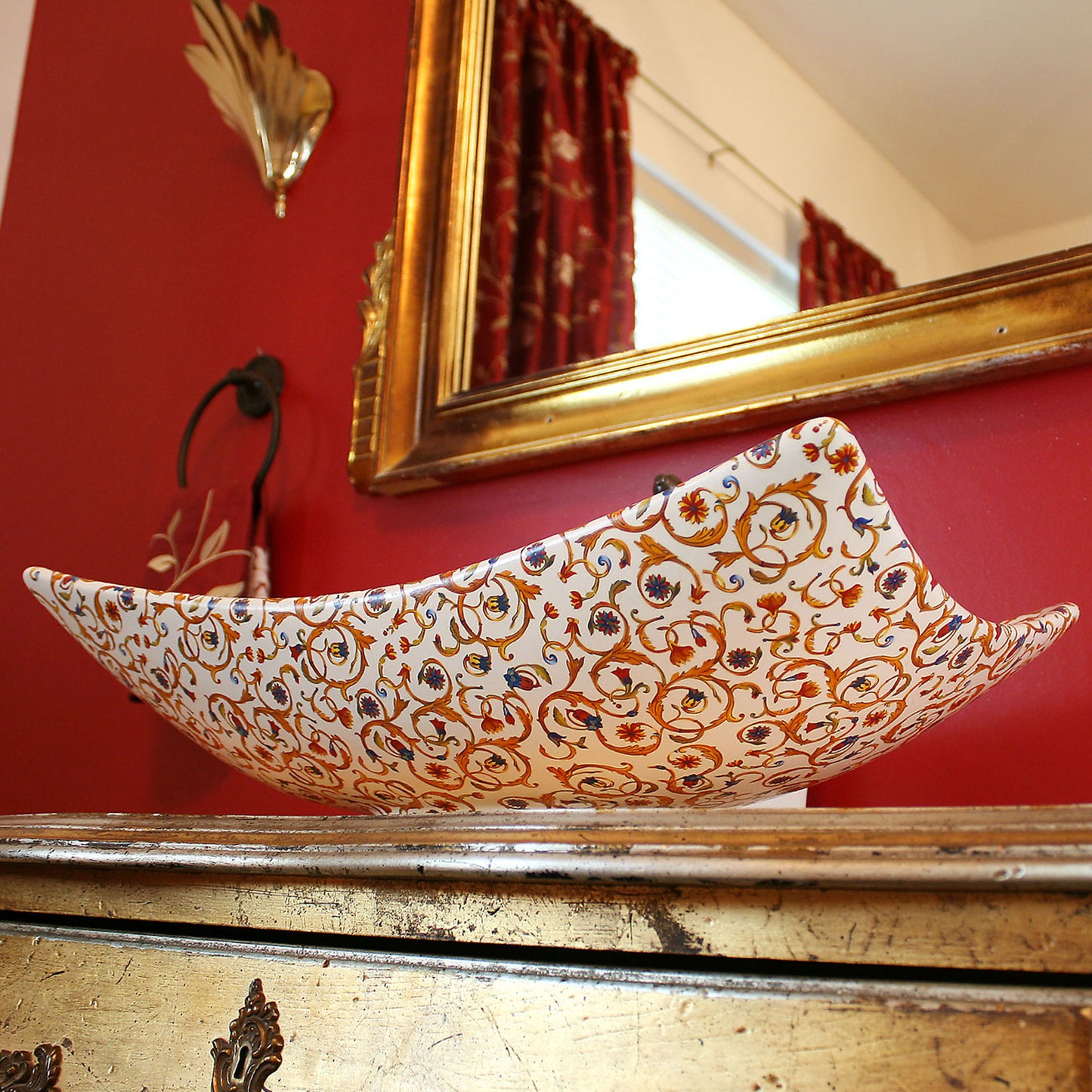 Red and gold powder room with unique Florentine painted vessel basin