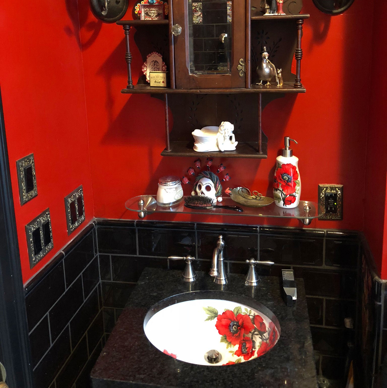 red bathroom with  poppies painted sink and soap dispenser